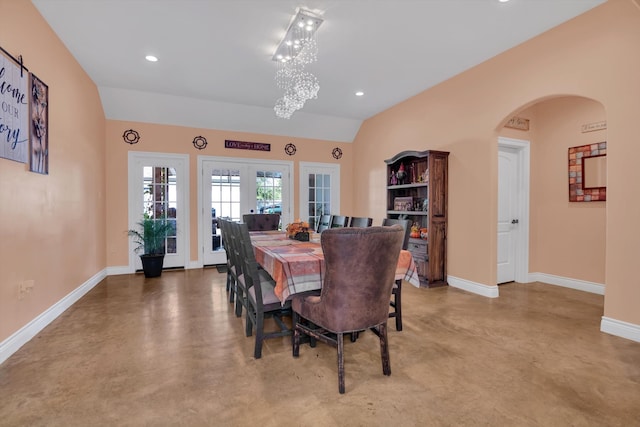 dining area with lofted ceiling, french doors, and an inviting chandelier