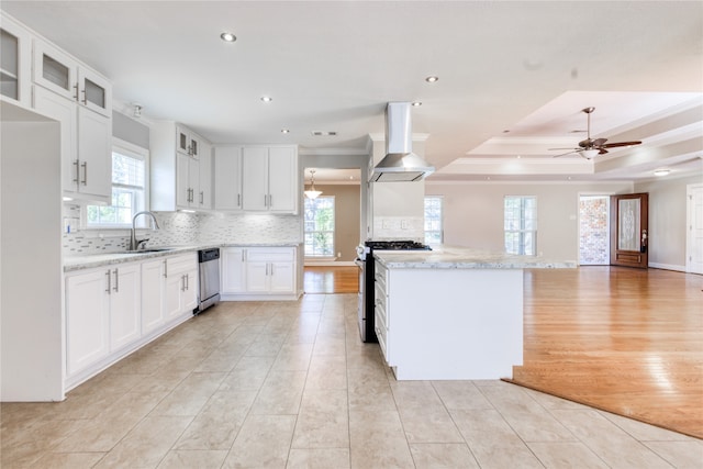 kitchen featuring a wealth of natural light, island range hood, appliances with stainless steel finishes, and white cabinets