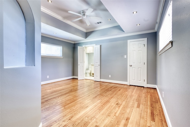 spare room featuring ceiling fan, a tray ceiling, ornamental molding, and light hardwood / wood-style flooring