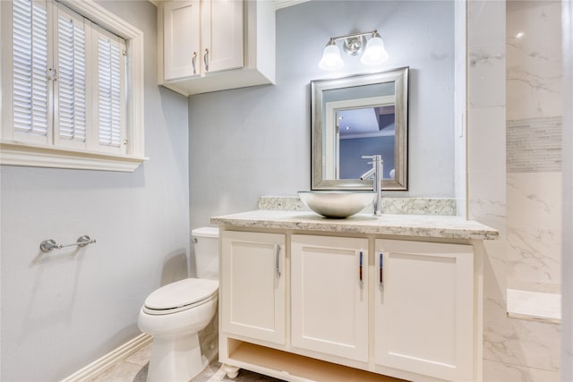 bathroom with vanity, a tile shower, and toilet