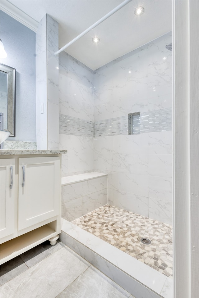 bathroom with vanity and tiled shower