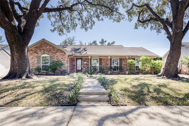 ranch-style house with covered porch and a front lawn