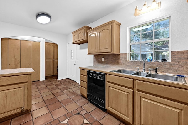 kitchen with decorative backsplash, light brown cabinetry, sink, dark tile patterned flooring, and black dishwasher