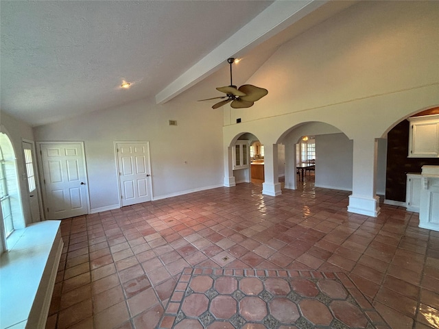 interior space with decorative columns, tile patterned floors, a textured ceiling, ceiling fan, and lofted ceiling with beams