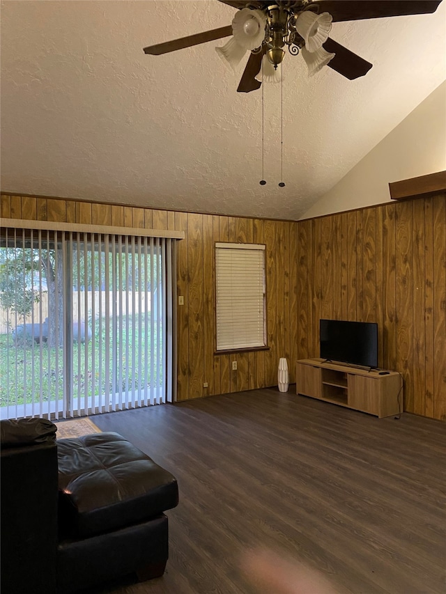 living room with a textured ceiling, ceiling fan, wooden walls, and dark hardwood / wood-style flooring