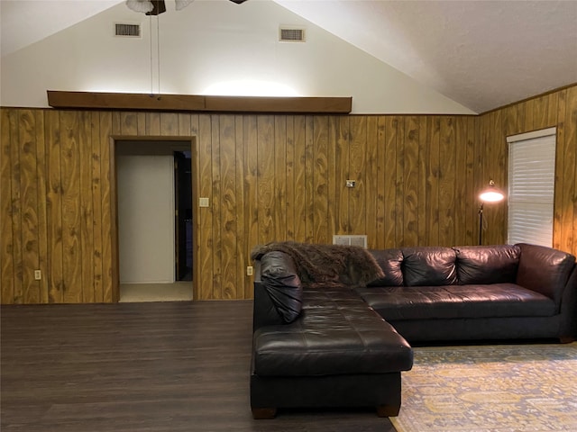 living room featuring wood walls, hardwood / wood-style floors, and vaulted ceiling