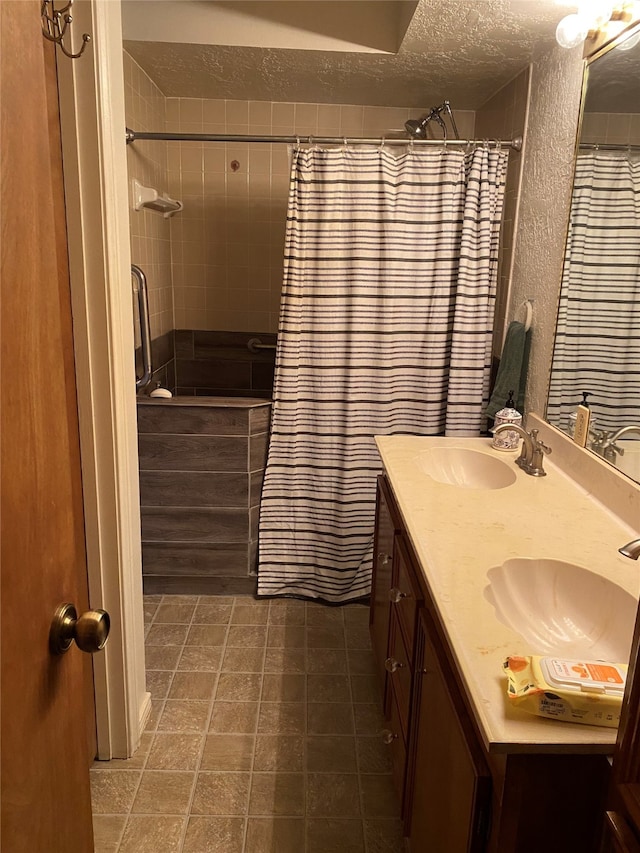 bathroom featuring vanity, a textured ceiling, and walk in shower