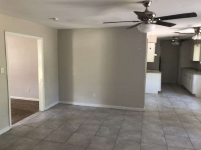 tiled empty room with ceiling fan