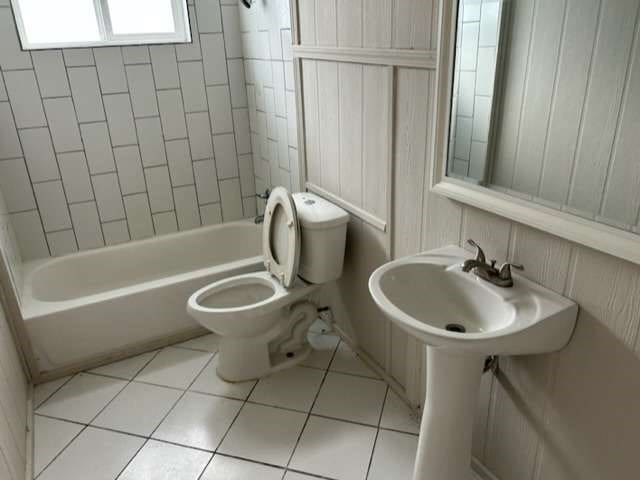 bathroom with toilet, tiled shower / bath combo, and tile patterned floors