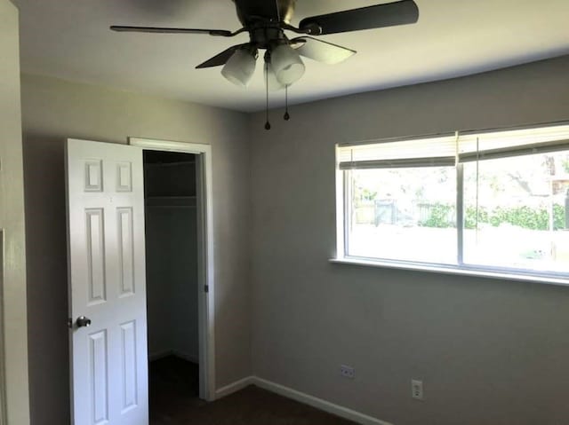 unfurnished bedroom with multiple windows, a closet, and ceiling fan