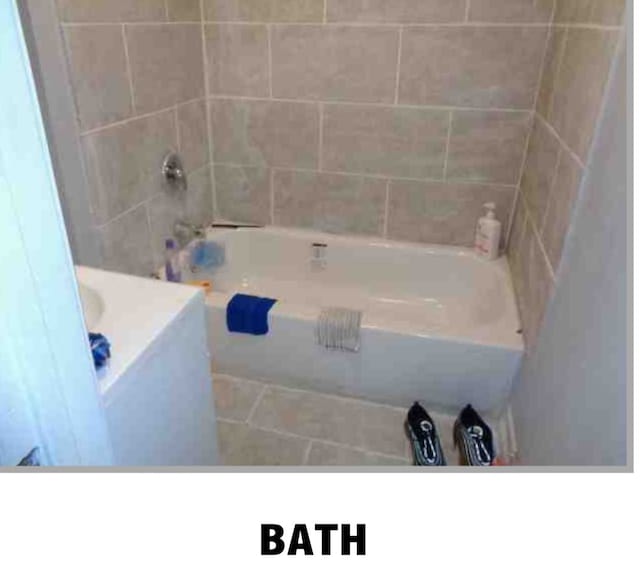 bathroom featuring vanity, tiled shower / bath combo, and tile patterned flooring