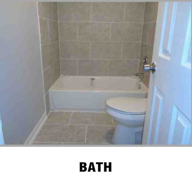 bathroom with tiled shower / bath, toilet, and tile patterned flooring