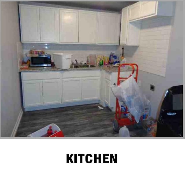 5417 Caplin St, Houston, TX 77026 - kitchen with dark wood-style flooring, a sink, light countertops, white cabinetry, and stainless steel microwave