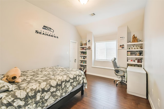 bedroom with vaulted ceiling and dark hardwood / wood-style floors