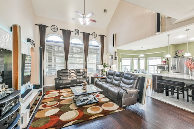 living room featuring ceiling fan, high vaulted ceiling, and dark hardwood / wood-style floors