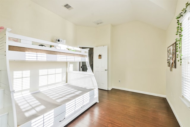 unfurnished bedroom featuring lofted ceiling and dark hardwood / wood-style floors