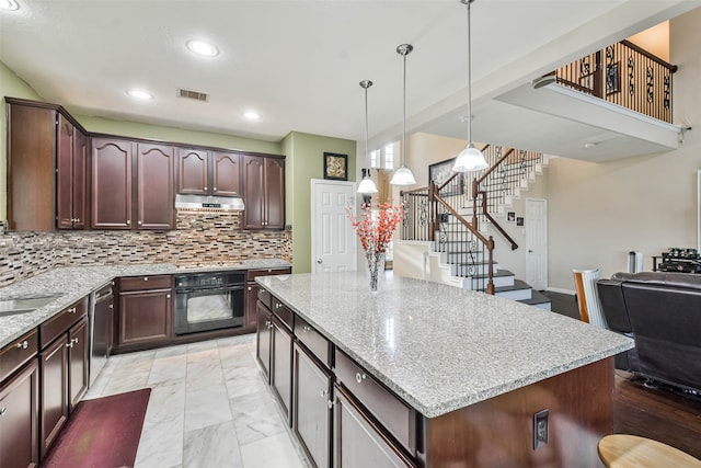 kitchen with hanging light fixtures, a center island, black oven, stainless steel dishwasher, and tasteful backsplash