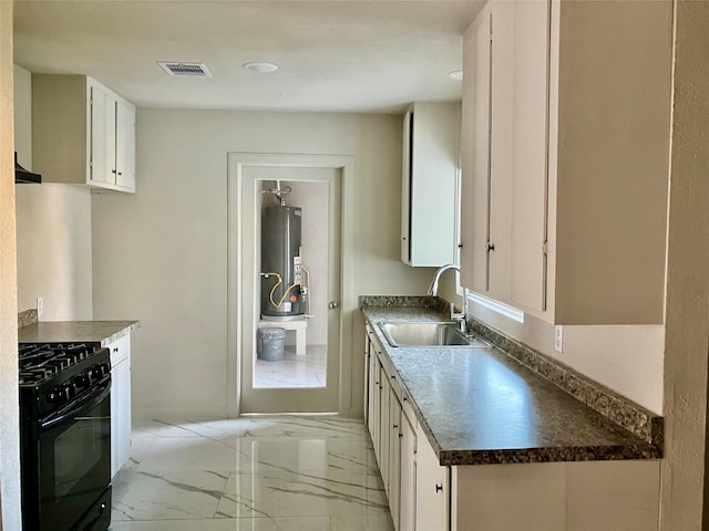 kitchen with sink, water heater, black stove, and white cabinets