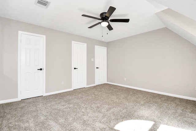 unfurnished bedroom with carpet floors, multiple closets, vaulted ceiling, and ceiling fan