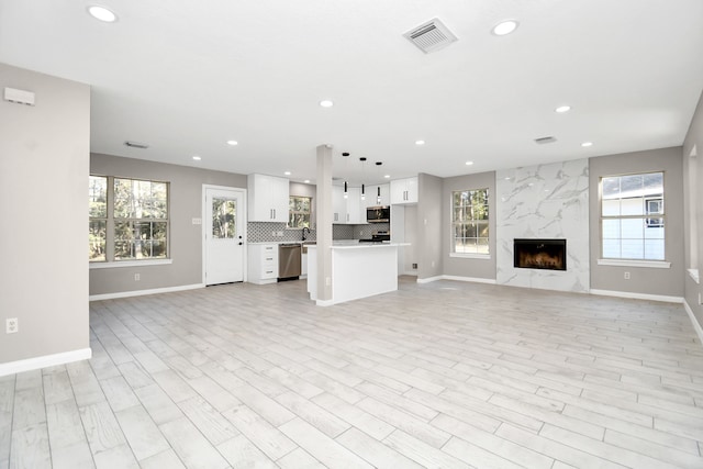 unfurnished living room with a premium fireplace and light wood-type flooring