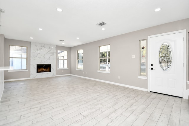 entrance foyer with light wood-type flooring and a fireplace