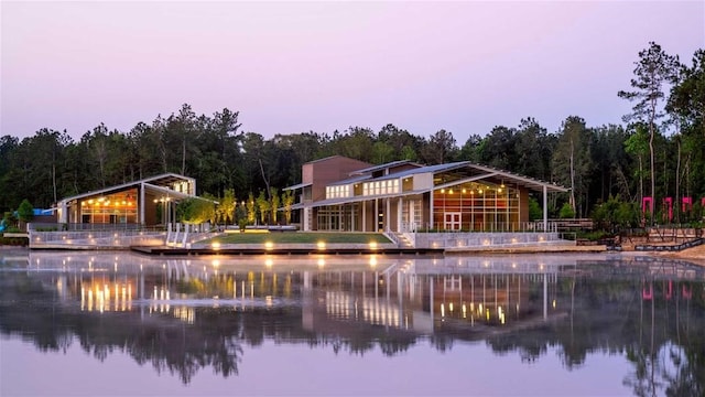 back house at dusk with a water view