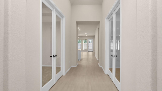 hallway featuring french doors and light hardwood / wood-style floors