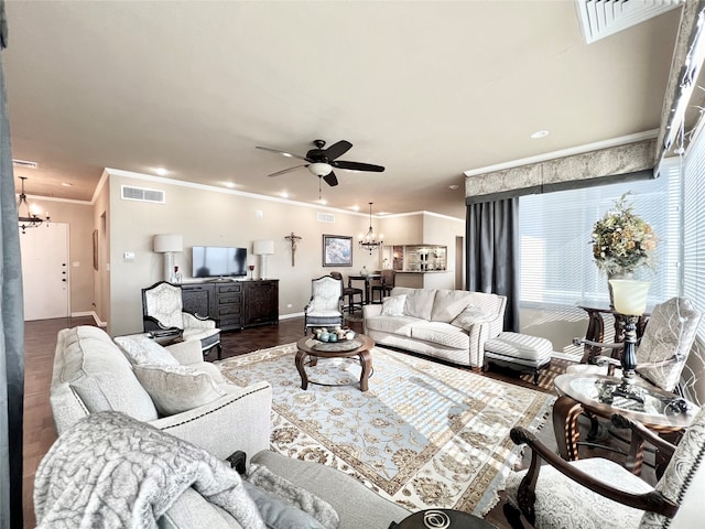 living room featuring hardwood / wood-style floors, crown molding, and ceiling fan with notable chandelier