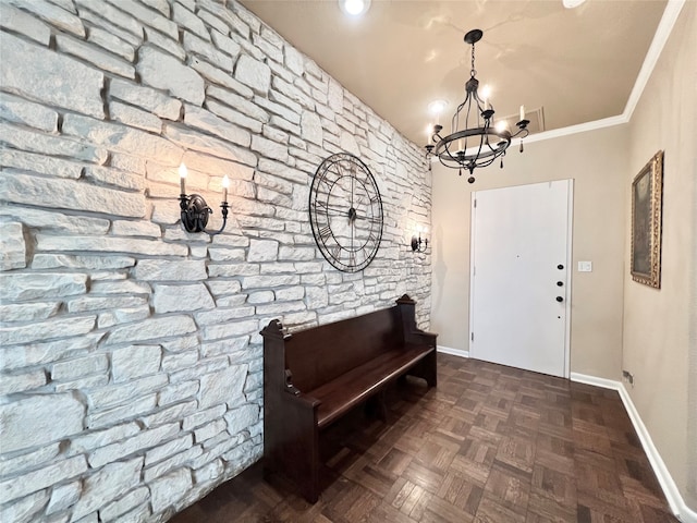 foyer featuring crown molding, a chandelier, and dark parquet flooring