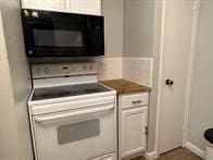 kitchen featuring white cabinetry and white electric range oven