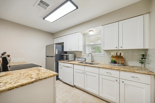 kitchen with sink, white cabinetry, decorative backsplash, and stainless steel appliances