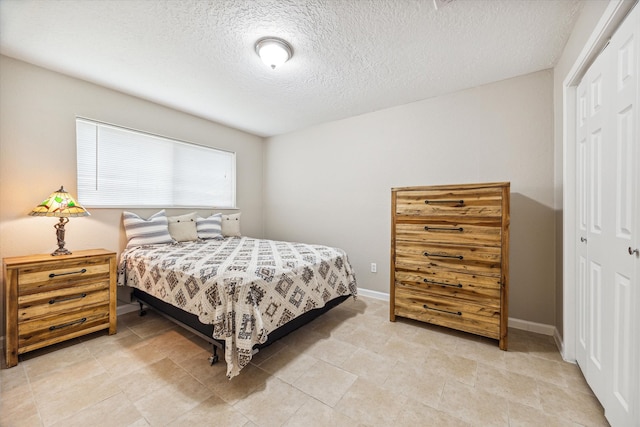 bedroom with a textured ceiling and a closet