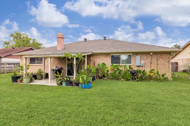 rear view of property with a patio area and a yard