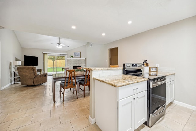 kitchen with kitchen peninsula, stainless steel electric stove, ceiling fan, vaulted ceiling, and white cabinets