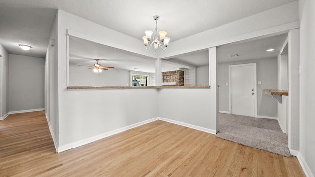 unfurnished room with light hardwood / wood-style flooring and ceiling fan with notable chandelier