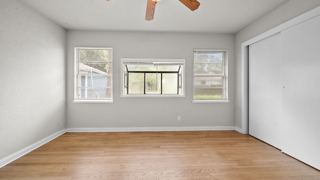 unfurnished bedroom with a closet, light hardwood / wood-style floors, and ceiling fan