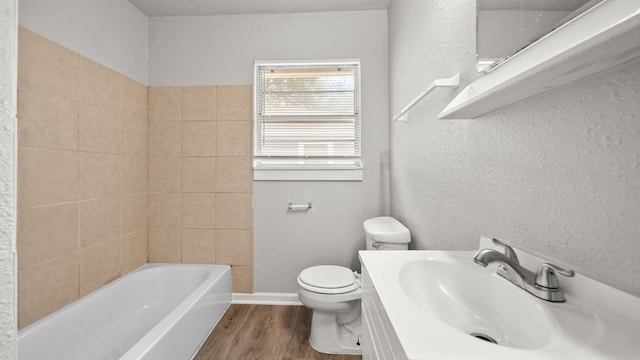 bathroom featuring vanity, a tub, wood-type flooring, and toilet