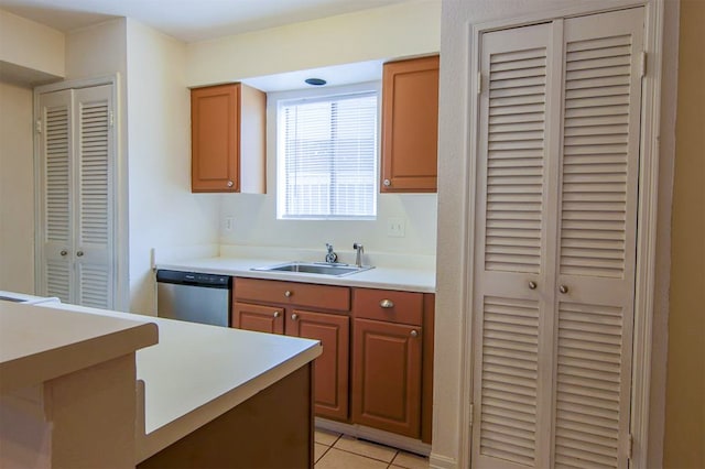 kitchen with stainless steel dishwasher, sink, and light tile patterned floors