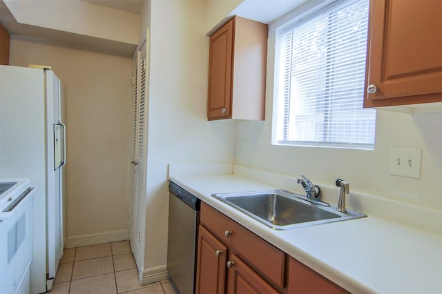 kitchen featuring a healthy amount of sunlight, sink, light tile patterned floors, and white appliances