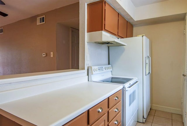 12100 Melville Dr Unit 402D, Montgomery, TX 77356 - kitchen with white electric range oven, under cabinet range hood, brown cabinets, and light countertops
