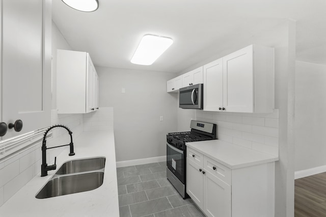 kitchen featuring sink, white cabinets, stainless steel appliances, and tasteful backsplash