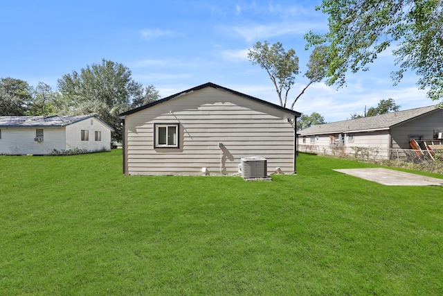 back of house with central air condition unit, a patio area, and a yard