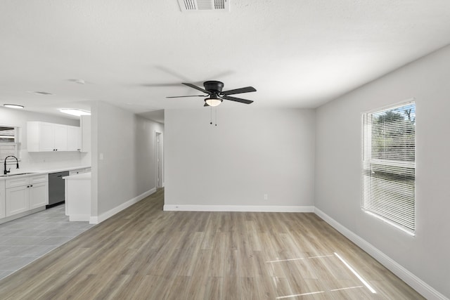 unfurnished living room featuring light hardwood / wood-style floors, sink, and ceiling fan