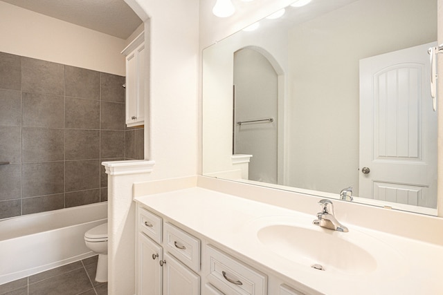 full bathroom featuring toilet, tiled shower / bath combo, vanity, and tile patterned flooring