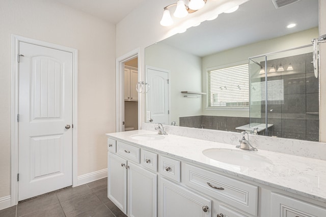 bathroom featuring a shower with door, vanity, and tile patterned floors