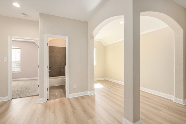 spare room with light hardwood / wood-style floors and crown molding