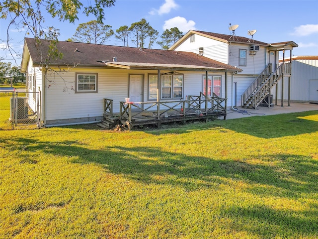 rear view of property with central air condition unit, a deck, and a lawn