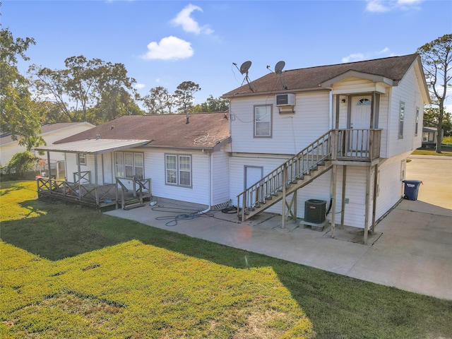 rear view of house featuring a patio area, cooling unit, a wall mounted AC, and a yard