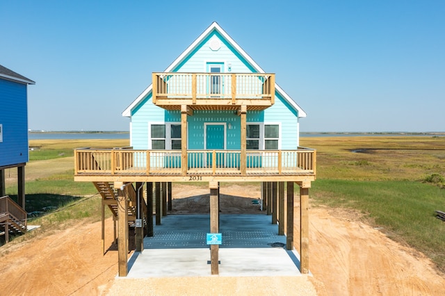 view of front of house featuring a wooden deck, a carport, and a rural view