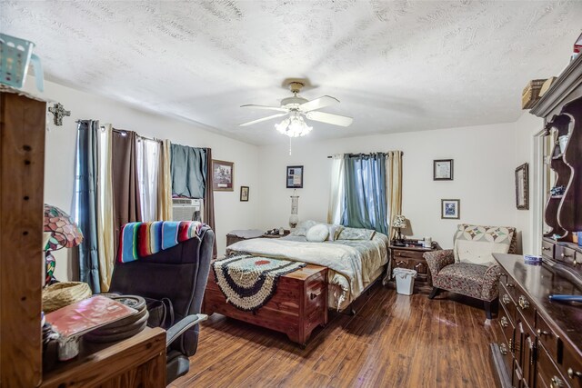 bedroom featuring dark hardwood / wood-style flooring, a textured ceiling, and ceiling fan